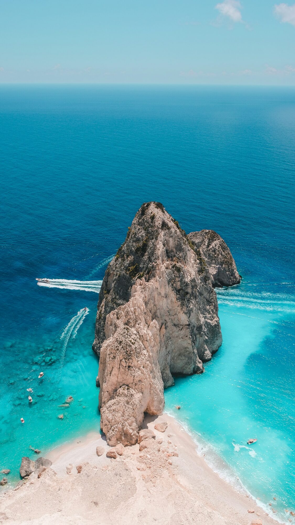 A speedboat navigating through a dramatic mountain sea tunnel in the stunning European waters - Horizon Luxury Crewed