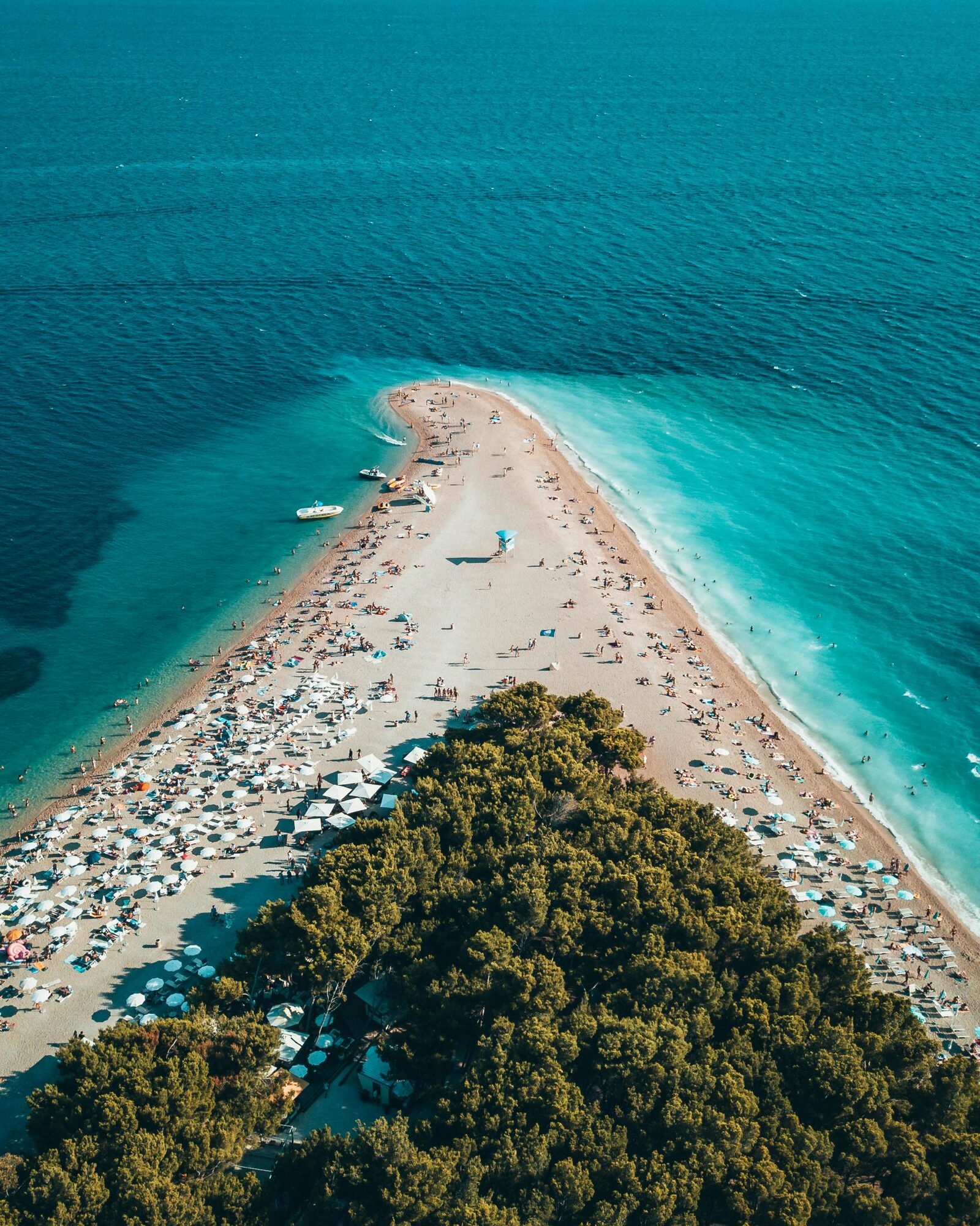 A vibrant and bustling Croatian beach packed with people soaking up the summer sun - Horizon Luxury Crewed