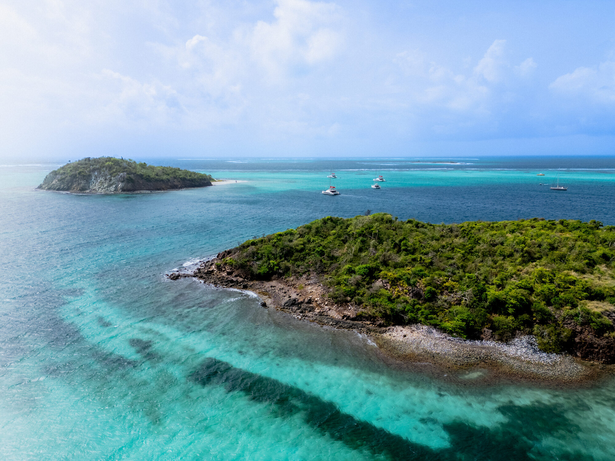 A stunning drone shot capturing the breathtaking coastline and turquoise waters of the Leeward Islands - Horizon Luxury Crewed