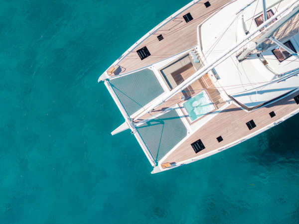Aerial view of a luxury crewed yacht gliding through open blue waters - Horizon Luxury Crewed