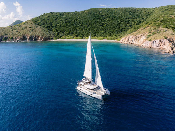A luxury sailing yacht cutting through vivid blue open waters - Horizon Luxury Crewed