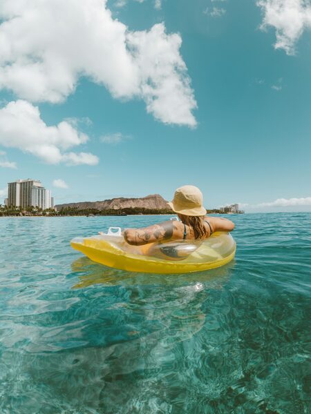 A guest relaxing and floating on the crystal-clear waters on an inflatable ring from a luxury crewed yacht - Horizon Luxury Crewed