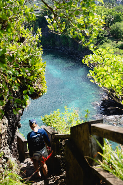 A crew member descending the swim steps of a luxury crewed yacht down to the glistening water - Horizon Luxury Crewed