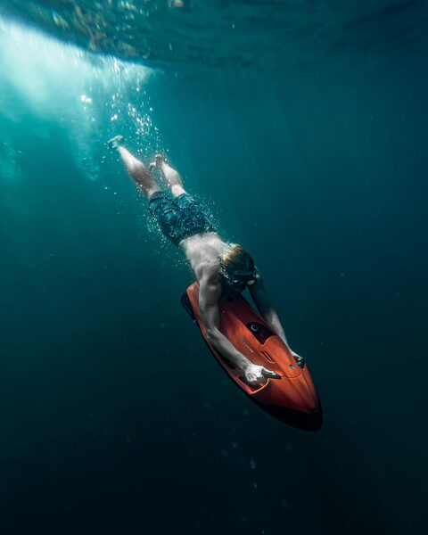 A guest sea bobbing through the dark crystal-clear waters on a luxury crewed yacht adventure - Horizon Luxury Crewed