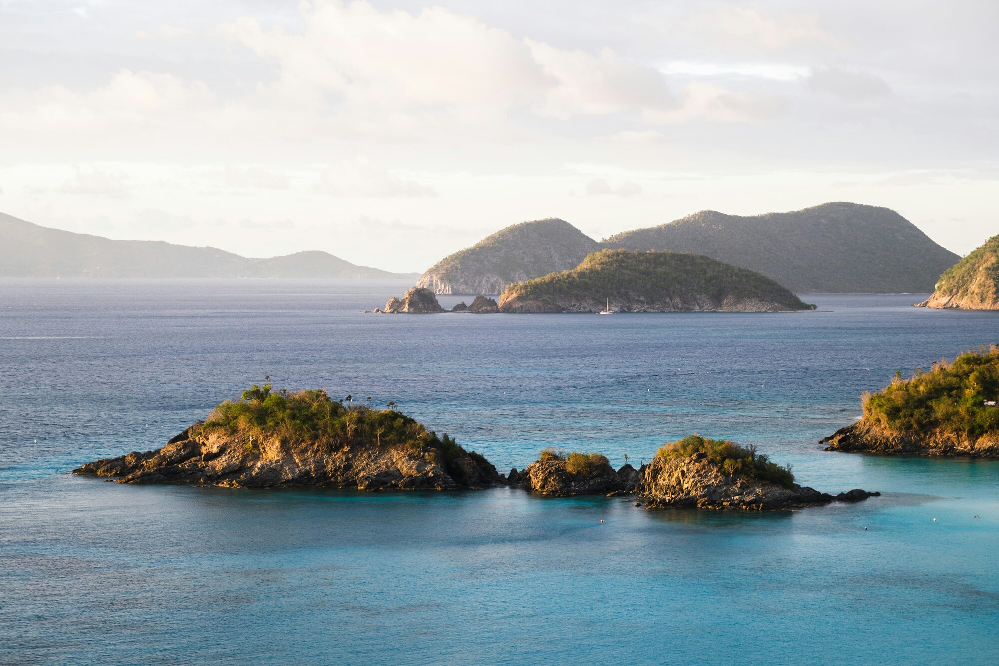 The dramatic rocky mountains of the US Virgin Islands rising above the shimmering turquoise waters - Horizon Luxury Crewed