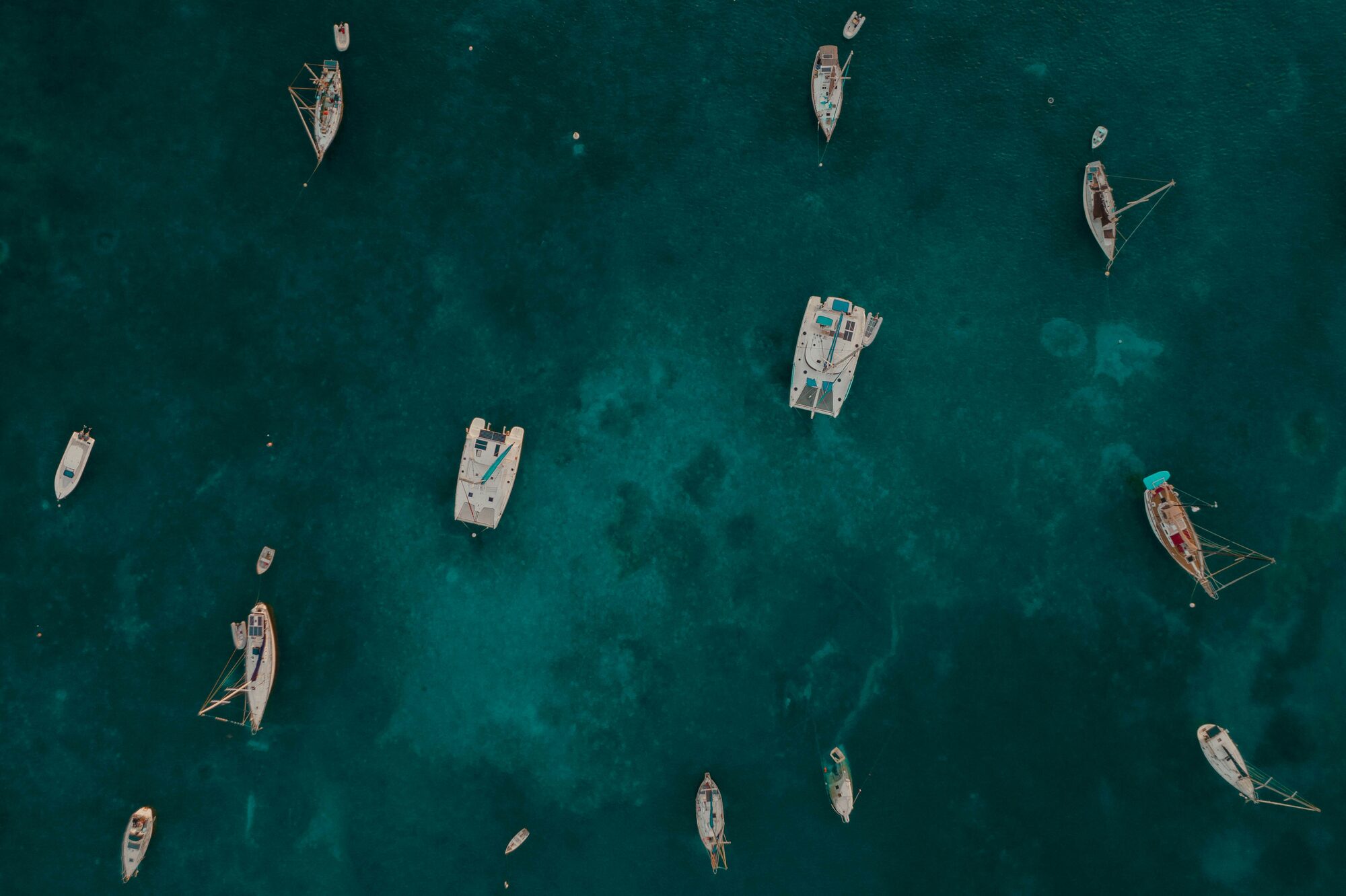 Aerial view of luxury yachts anchored in stunning crystal-clear waters - Horizon Luxury Crewed